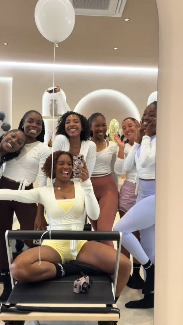 Members celebrating together in the studio mirror after a class