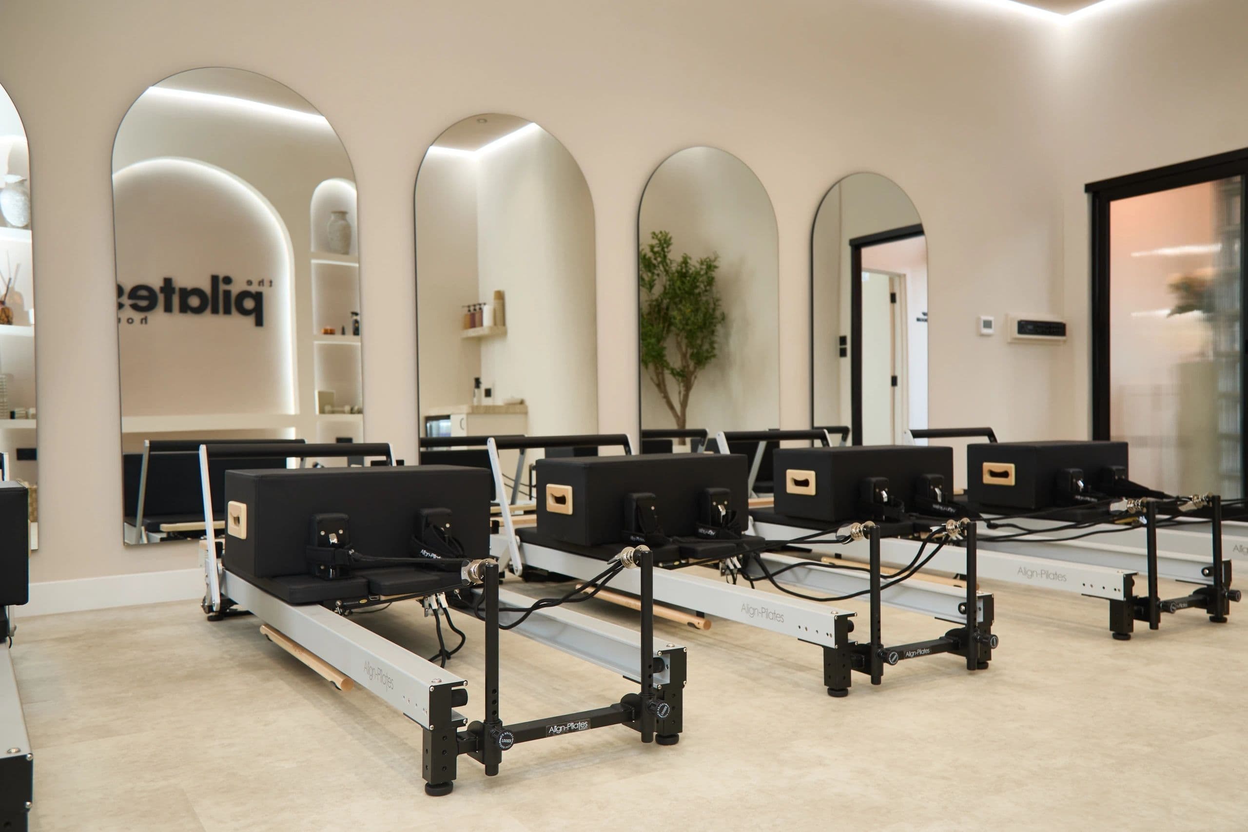 The reformer studio at The Pilates Grounds, seven AlignPilates reformers under arched mirrors